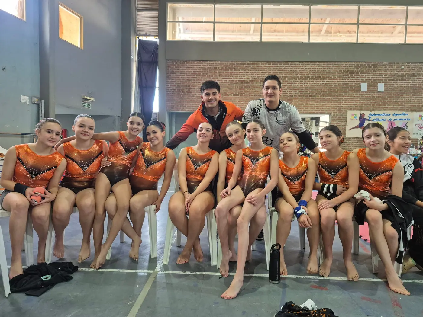 Equipo de gimnastas con la malla de competencia en el gimnasio